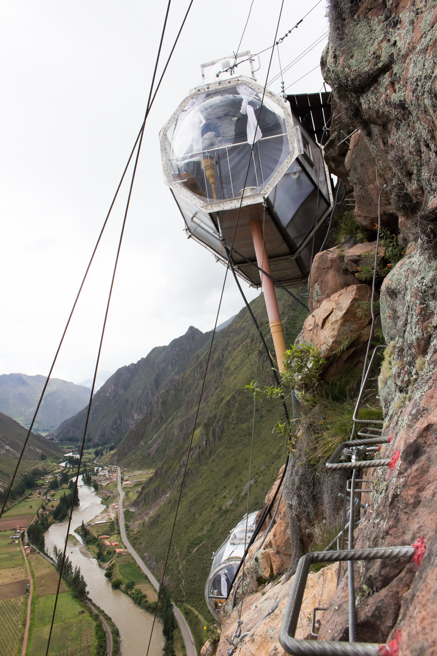 Skylodge Adventure Suites, Urubamba Valley, hanging pods, transparent accommodation, cliffside stay, thrilling experience, panoramic views, unique lodging, Peru, adventure travel, cliff suspension, unforgettable stay, elevated lodging, cliffside pods, mountain retreat, Urubamba River, extreme accommodation, mountainous landscape, Andes Mountains, Skylodge review
